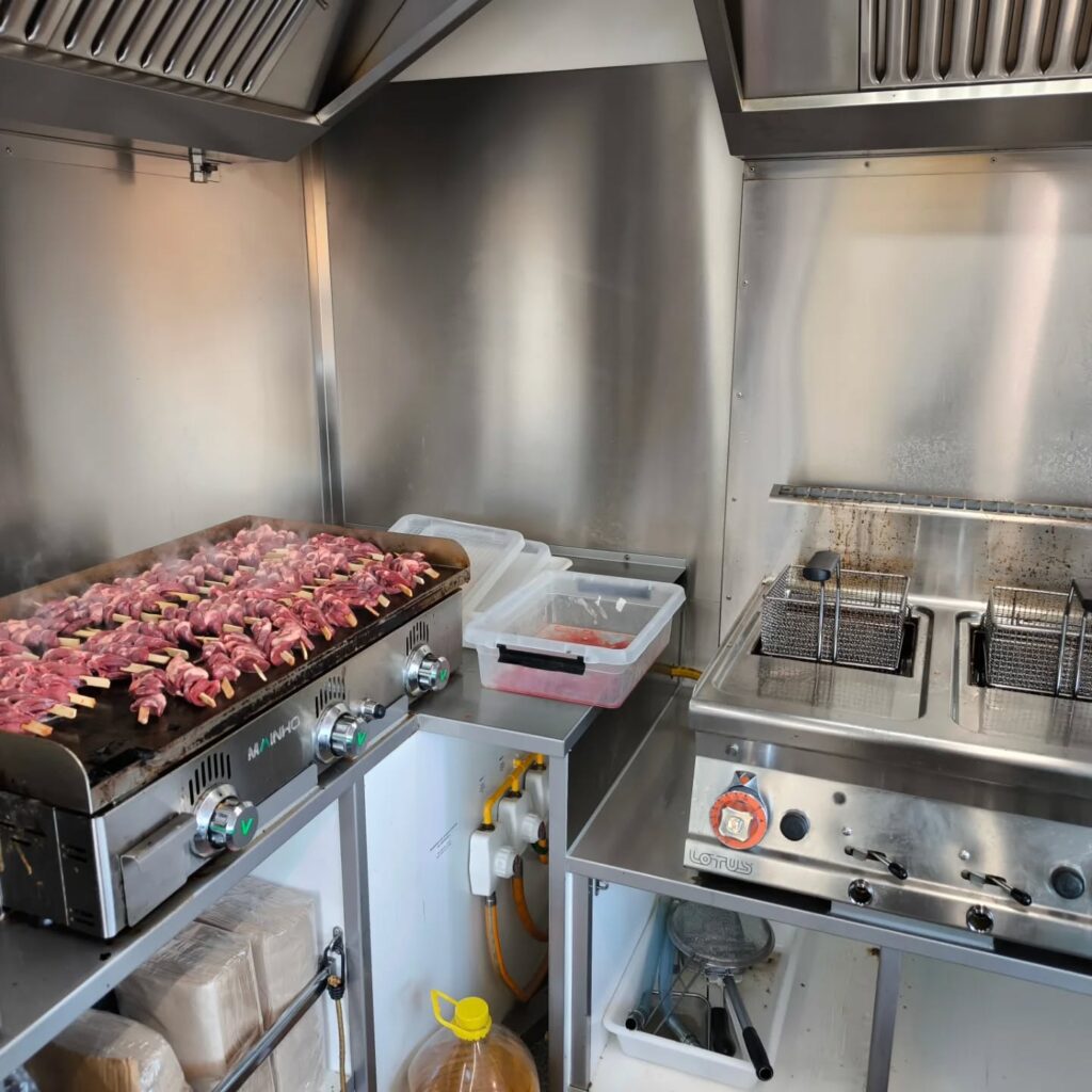 Brochettes viande sur plancha MAÍNH O et friteuse Cuisine professionnelle avec brochettes de viande crues sur plaque chauffante MAÍNH O et friteuse double LOTUS en inox.